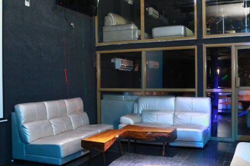 two white leather couches and a coffee table in a room at Tiffany Diamond Hotels Ltd - Indira Gandhi street in Dar es Salaam