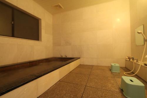 a bathroom with a sink and a tv on the wall at Warabiso in Yuzawa