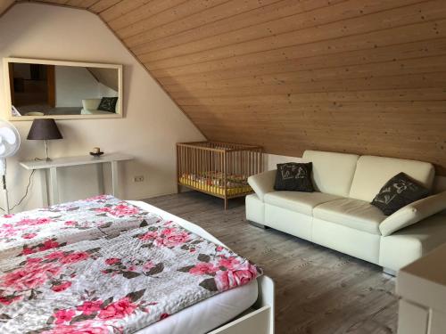 a bedroom with a bed and a couch at Ferienwohnung Held in Erding