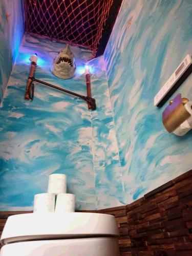 a bathroom with a toilet and a mural of clouds at Yadoya Lodge in Kyoto