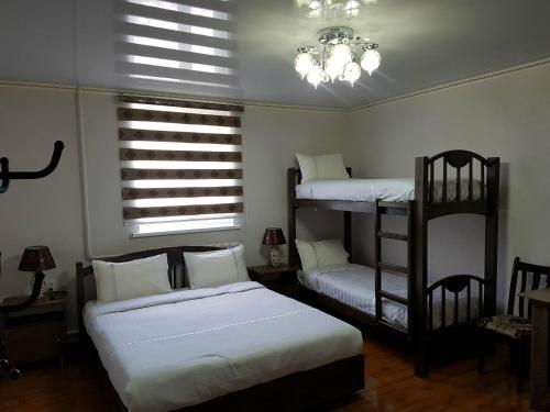a bedroom with two bunk beds and a chandelier at Datka Guest House in Naryn