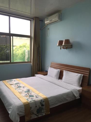 1 dormitorio con cama y ventana en Huashan International Youth Hostel, en Huayin