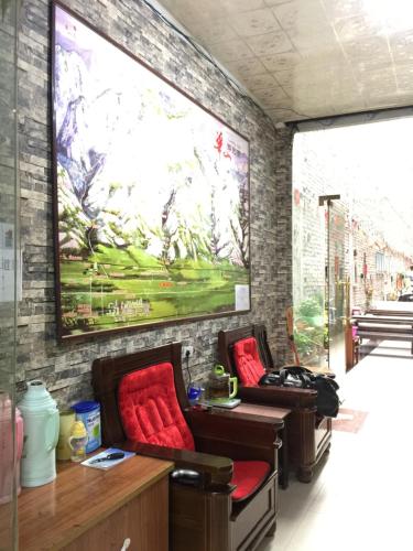 a room with couches and a large painting on the wall at Huashan International Youth Hostel in Huayin