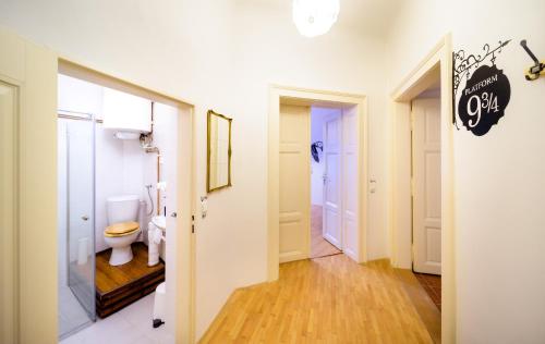 La salle de bains blanche est pourvue de toilettes et d'un couloir. dans l'établissement Amazing Harry Potter's apt. at Old Town, à Prague