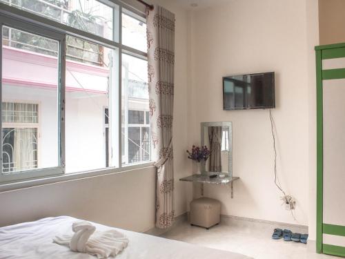 a bedroom with a bed and a window at Yen Ngoc Guesthouse in Da Lat