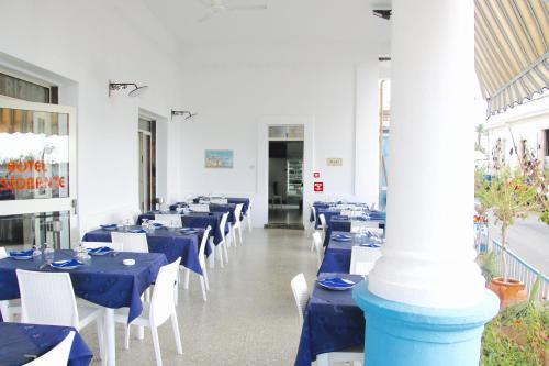 a dining room with blue tables and white chairs at Hotel Rizieri in Leuca
