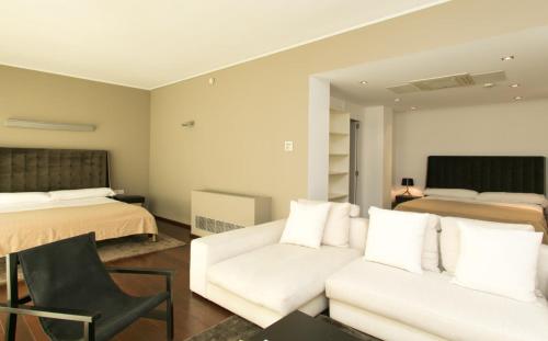 a bedroom with a white couch and a bed at Hotel Zhero in Cas Catala
