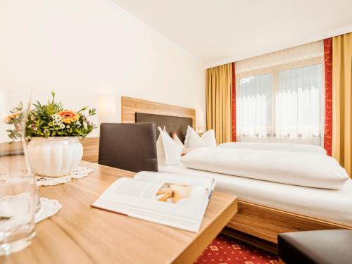 a hotel room with two beds and a desk at Hotel Finkenbergerhof in Finkenberg