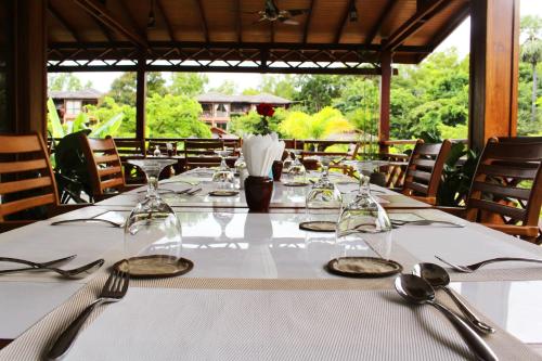 Popaywa波帕花园度假村的一张桌子上放着白色的桌布和银器
