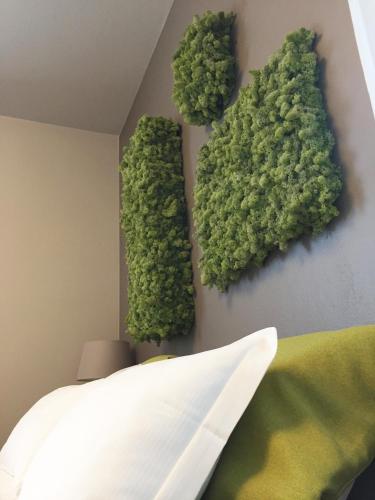 a bedroom with green plants on the wall at Art B&B Design in Costa Volpino