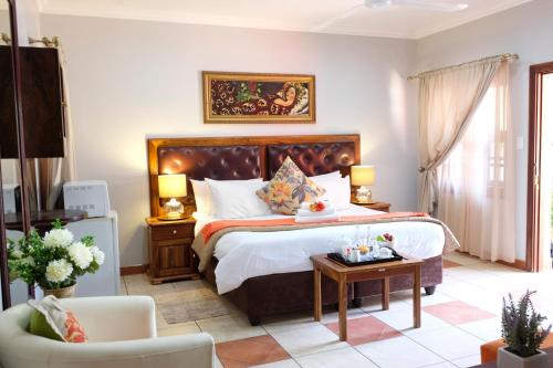 1 dormitorio con 1 cama grande y 1 mesa en Waterkloof Guest House en Pretoria