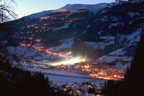 a town on a mountain in the snow at night at Appartement Wildkogel in Neukirchen am Großvenediger