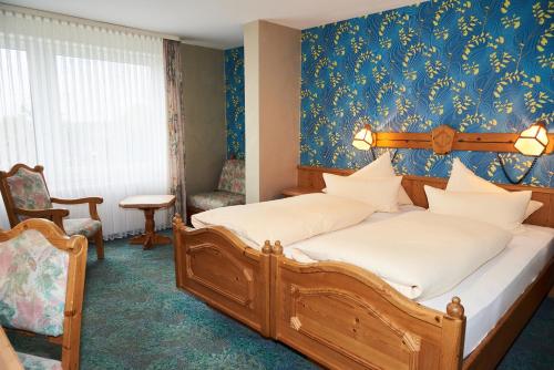 um quarto com uma cama e uma parede azul em Hotel Odenwaldblick em Rödermark