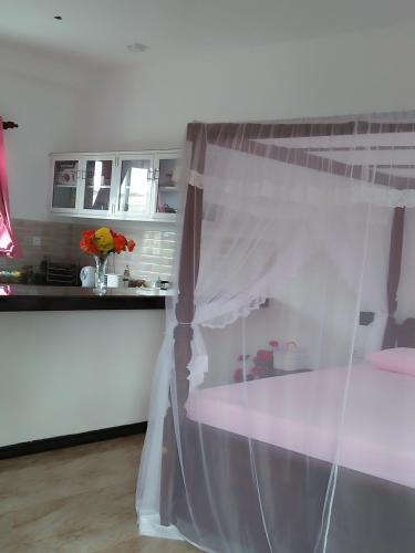 a bedroom with a bed with a canopy at Indika's Apartment in Hikkaduwa