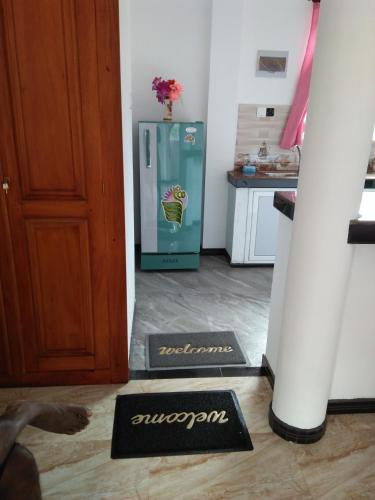 a kitchen with a refrigerator with a flower on it at Indika's Apartment in Hikkaduwa