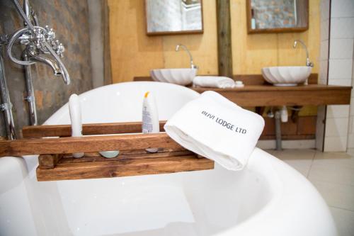 a bathroom with a sink and a bath tub at Buvi Lodge Limited in Entebbe