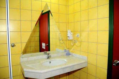 a yellow tiled bathroom with a sink and a mirror at Sunway Apart Hotel in Alanya