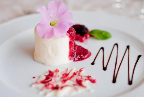 a dessert with a pink flower on a white plate at Hotel Al Cervo in Tesero