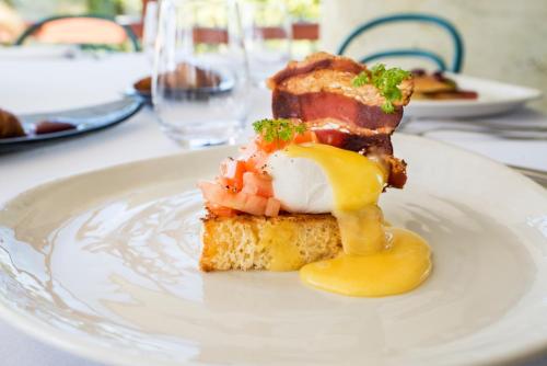 a white plate with a piece of food on a table at Sala Resort Plateliai & SPA in Plateliai