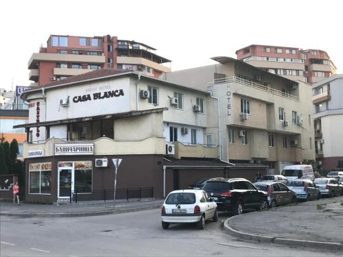 a building with cars parked in a parking lot at Casa Blanca in Sofia