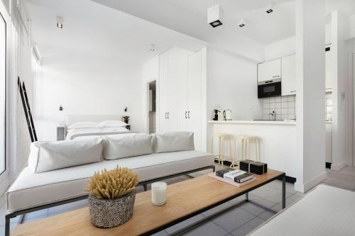 a white living room with a couch and a table at Euryclea Residences in Athens