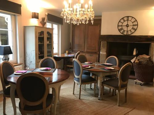 a dining room with tables and chairs and a chandelier at Logis Hôtel DOMAINE du MOULIN in Saint-Avold