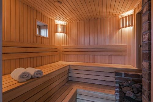 a wooden sauna with two towels sitting in it at Sala Resort Plateliai & SPA in Plateliai