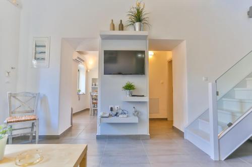 a living room with a staircase and a tv at Annika Deluxe Apartments in Symi