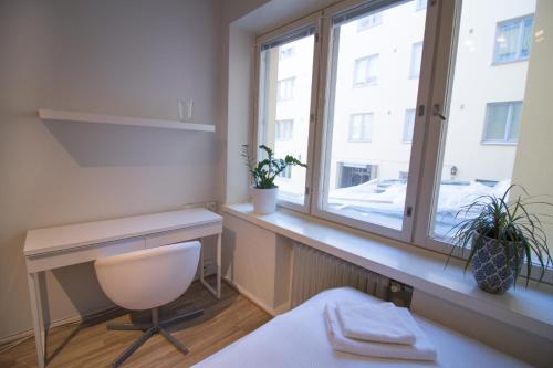 ヘルシンキにあるセカンドホーム ピエタリンカトゥ アパートメント 2のデスクと窓が備わる客室です。