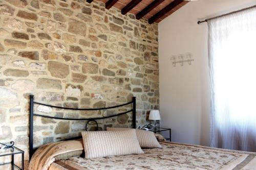 プラトヴェッキオにあるAgriturismo Mandrioliの石壁のベッドルーム(ベッド付)