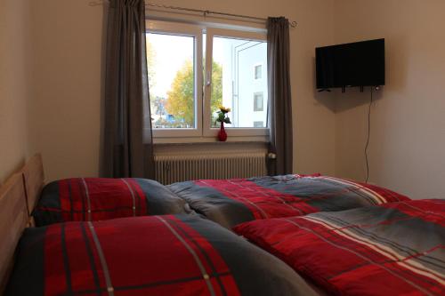 - 2 lits dans une chambre avec fenêtre dans l'établissement Ferienwohnung Albblick 1 Münsingen, à Münsingen