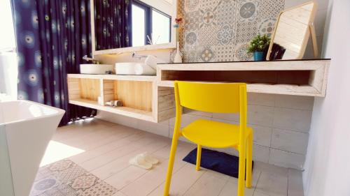 a yellow chair in a bathroom with a sink at 湛藍海岸民宿 Azure-零泊預約居-這個夏天有點藍--墾丁南灣沙灘-可包棟-國旅卡 in Nanwan