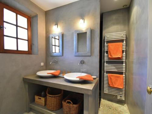 La salle de bains est pourvue de 2 lavabos et de serviettes orange. dans l'établissement Villa in Roussillon with Private Pool, à Roussillon