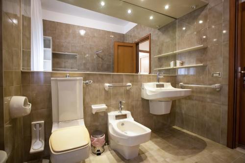 een badkamer met een wastafel, een toilet en een spiegel bij Settimo Cielo in Caltagirone