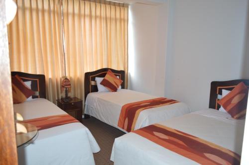 a hotel room with two beds and a window at Andino Classic in Machu Picchu