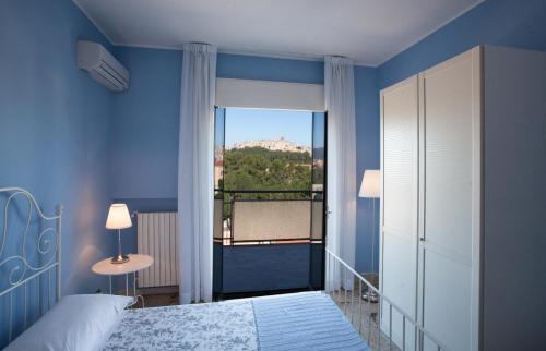 een blauwe slaapkamer met een bed en een balkon bij Settimo Cielo in Caltagirone