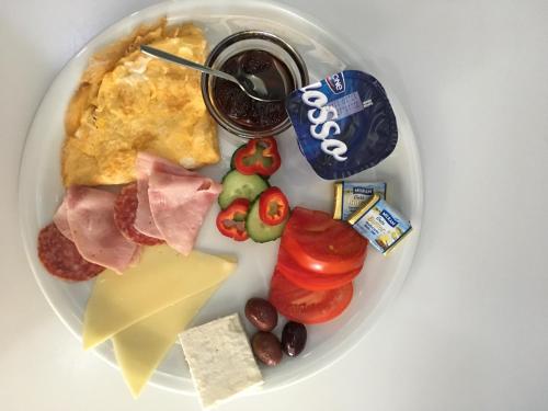 a plate of food with meat cheese and other foods at Graffiti Hotel in Bucharest