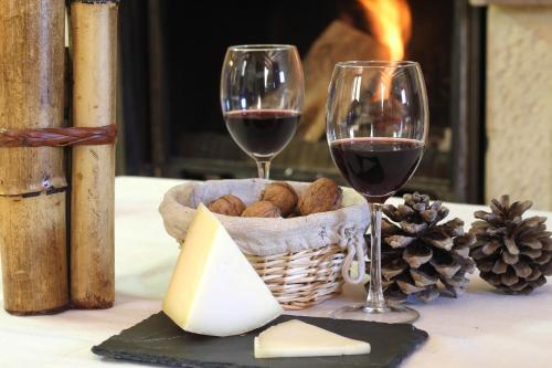 una mesa con dos copas de vino y una cesta de queso en Hostal Rural Ioar, en Sorlada