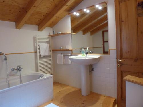 a bathroom with a sink and a bath tub and a mirror at Olive Press Lodge in Chiavari