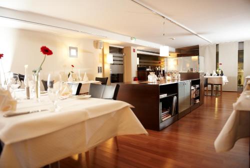 un restaurante con dos mesas y un bar en el fondo en Altera Hotel, en Oldenburg