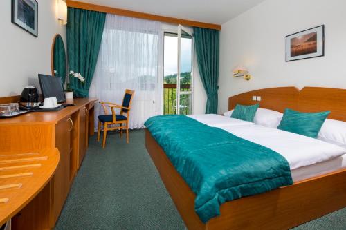 una camera d'albergo con letto e scrivania con computer di Spa Resort Libverda - Hotel Nový Dům a Lázně Libverda