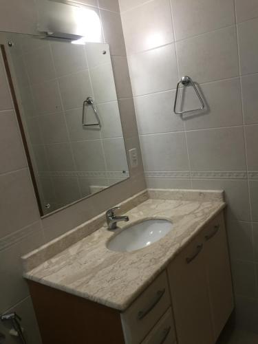 een badkamer met een wastafel en een spiegel bij Res. Alcides Balzaretti in Gramado