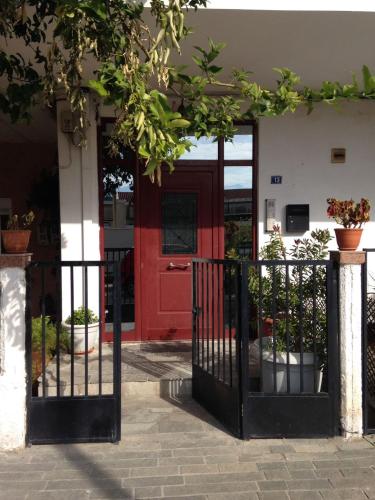 a red door of a building with potted plants at Cozy Loft - Best view of the city in Lamía