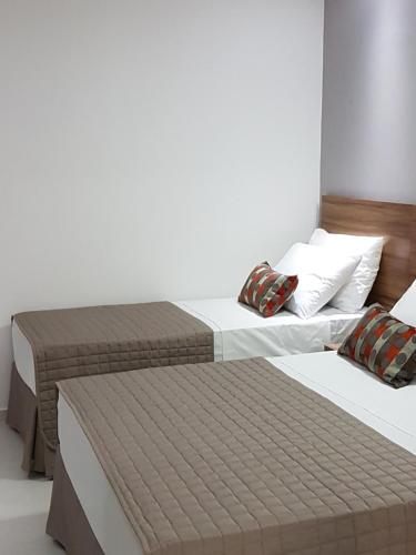 two twin beds in a room with at Pousada la Portella in Cabo Frio