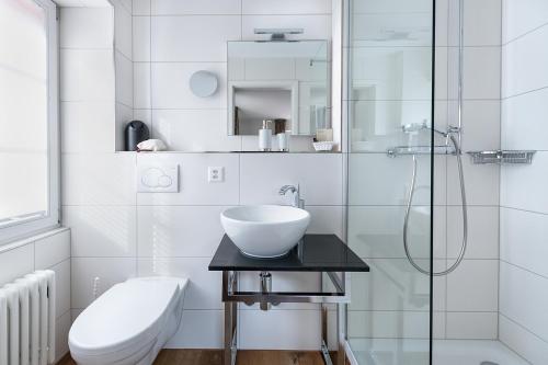 a white bathroom with a sink and a shower at Hotel Bären in Oberbipp