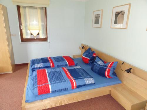a bedroom with a bed with blue and red pillows at Haus Oberwiesenthal in Kurort Oberwiesenthal