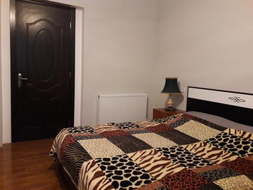 um quarto com uma cama e uma porta preta em Goga Guesthouse em Signagi