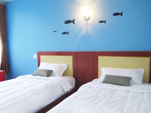 2 Betten nebeneinander in einem Zimmer in der Unterkunft Your Place Inn Surin in Surin
