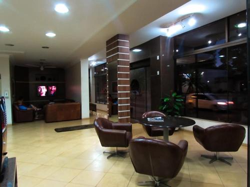 a lobby with a table and chairs in a building at Dourados Center Hotel in Dourados