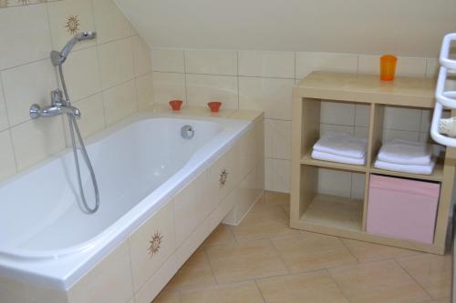 a bathroom with a tub and a shelf with towels at Villa Sole in Pruszcz Gdański